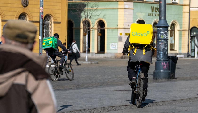 Dostawcy na rowerach przejeżdżają przez rynek