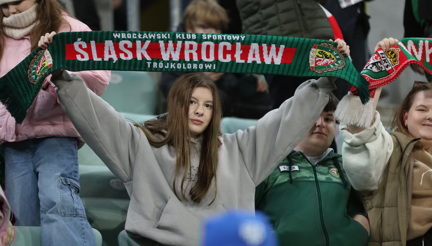 Mecz Śląska z Pogonią 7.03.2025, zdjęcia kibiców. Na zdjęciu młoda kobieta z szalikiem Śląska