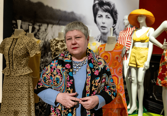 Kuratorka Małgorzata Możdżyńska-Nawotka na wystawie ubrań z garderoby prof. Ireny Huml, w tle zdjęcie pani profesor