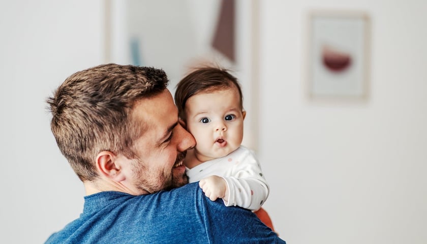 Mężczyzna trzyma małe dziecko na rękach, zdjęcie ilustracyjne 