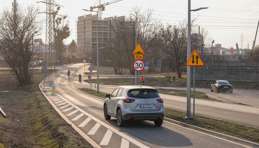 Samochód jadący nowym zjazdem z alei Wielkiej Wyspy na ulicę Wilczą 