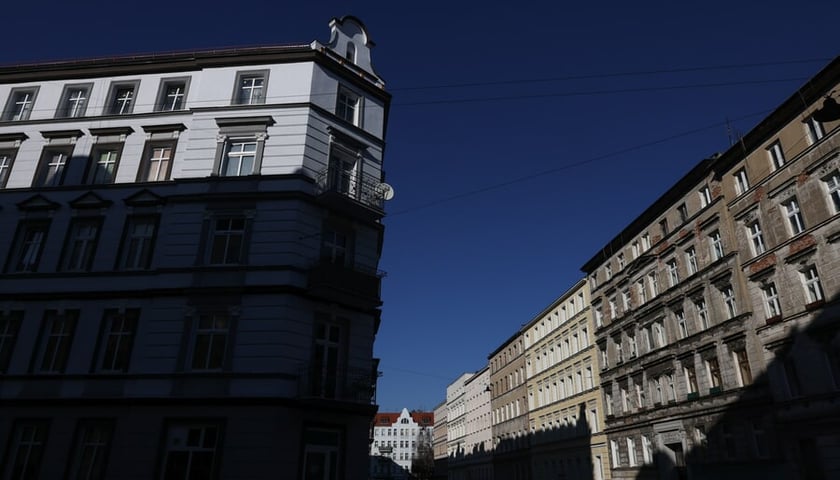 Po lewej stronie kadru widać odnowioną kamienicę Chudoby 15, jej większa część jest w cieniu (marzec 2025)