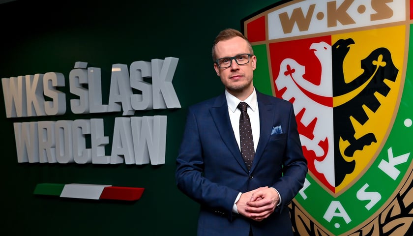 Michał Mazur, nowy prezes Śląska Wrocław. W tle napis i logo klubu