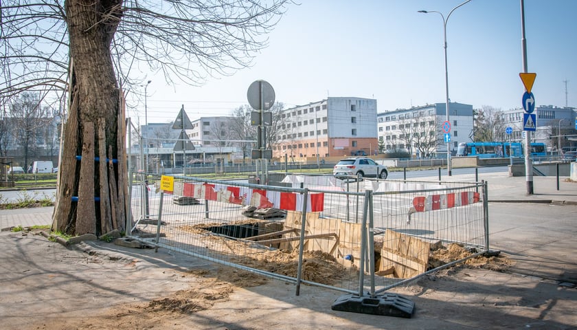 Wykop w ulicy i chodniku, w tle bloki i samochody jadące po ul. Legnickiej