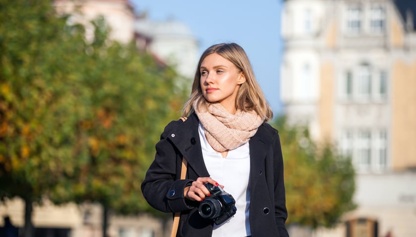 Kobieta z aparatem fotograficznym w ręku, zdjęcie ilustracyjne