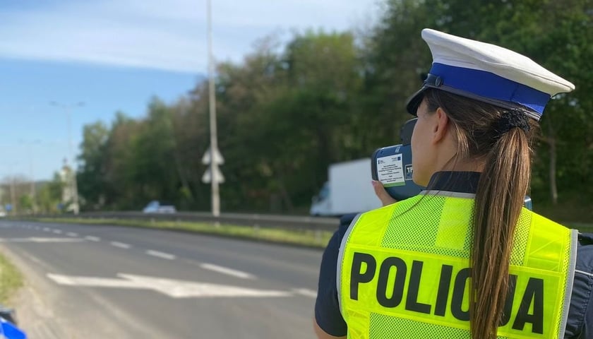 Policjantka z urządzeniem do pomiaru prędkości podczas kontroli drogowej