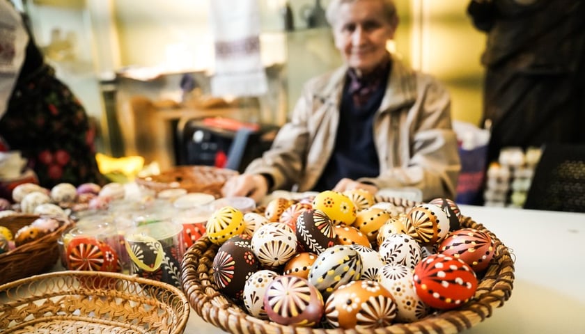 Pisanki w koszu na stole (zdjęcie ilustracyjne)