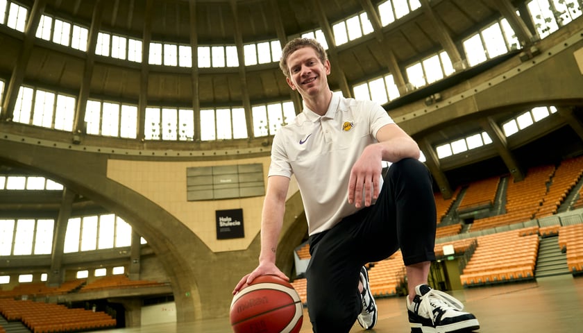 Bronisław Wawrzyńczuk - łowca talentów NBA  - pozuje z piłką wewnątrz Hali Stulecia