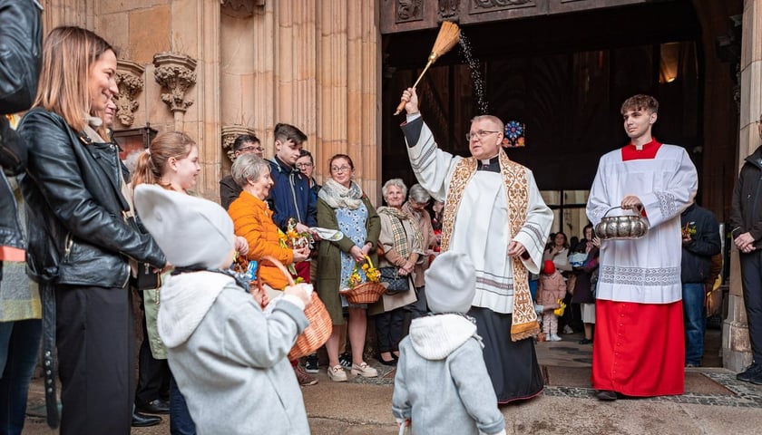 Święcenie pokarmów przed katedrą wrocławską. Ksiądz i mieszkańcy z koszyczkami