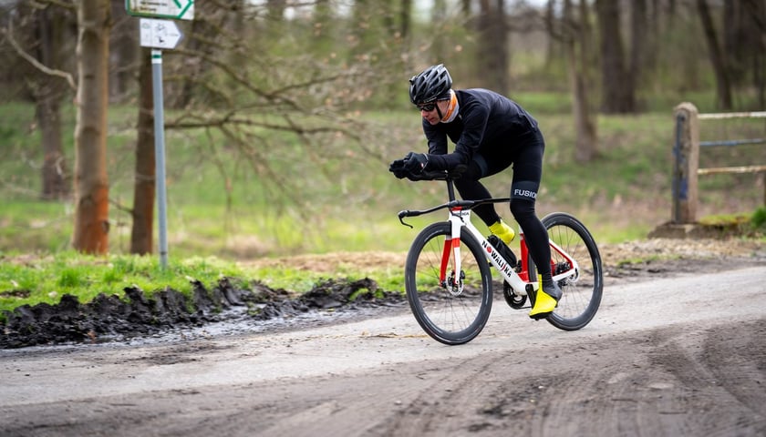Triathlonowiec Adrian Kostera na trasie koło Milicza. Na zdjęciu mężczyzna na rowerze