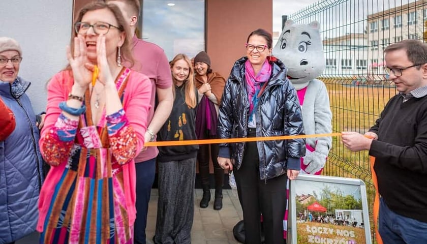 Grupa ludzi i maskotka hipopotama tuż przed przecięciem wstęgi przed budynkiem CAL-u na Zakrzowie (zdjęcie ilustracyjne)