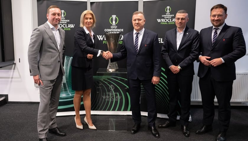 Marcin Przychodny, prezes Tarczyński Areny, Renata Granowska, wiceprezydent Wrocławia, Cezary Kulesza, prezes PZPN, Łukasz Wachowski, sekretarz generalny PZPN stoją na tle pucharu i ścianki dotyczących finału LKE we Wrocławiu