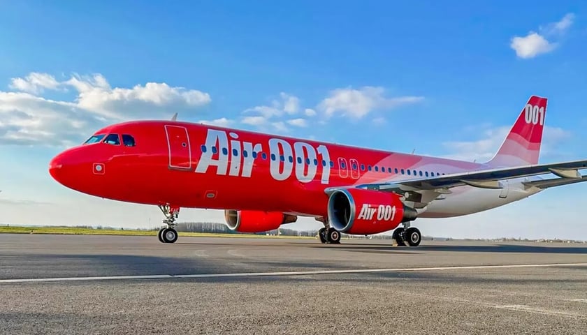 Czerwony airbus z białym napisem Air 001 na płycie lotniska (zdjęcie ilustracyjne)