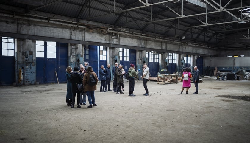 Grupa osób w hali na Kolejowej pod nową siedzibę BWA Wrocław, marzec 2025