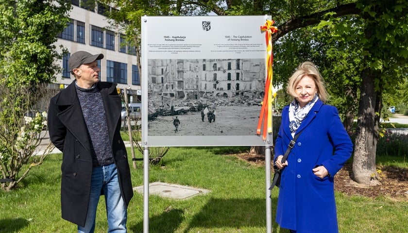Odsłonięcie tablicy w 80. rocznicę kapitulacji Festung Breslau. Na zdjęciu tablica ze zdjęciem, przy której po jednej stronie stoi  Piotr Matunin z Wydziału Promocji i Turystyki Urzędu Miasta Wrocławia, a po drugiej Aleksandra Mańczyńska, zastępca dyrektora Muzeum Miejskiego Wrocławia.