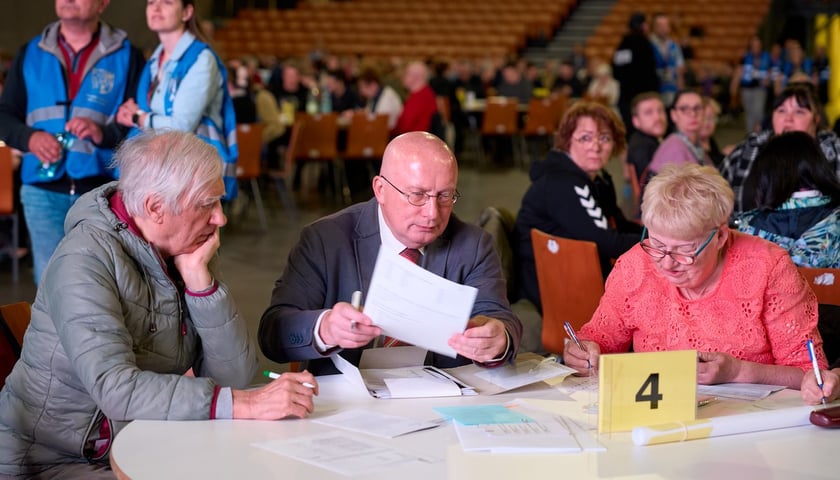 Szkolenie dla członków obwodowych komisji wyborczych we Wrocławiu. Na zdjęciu przy stoliku z dokumentami siedzi kilka osób