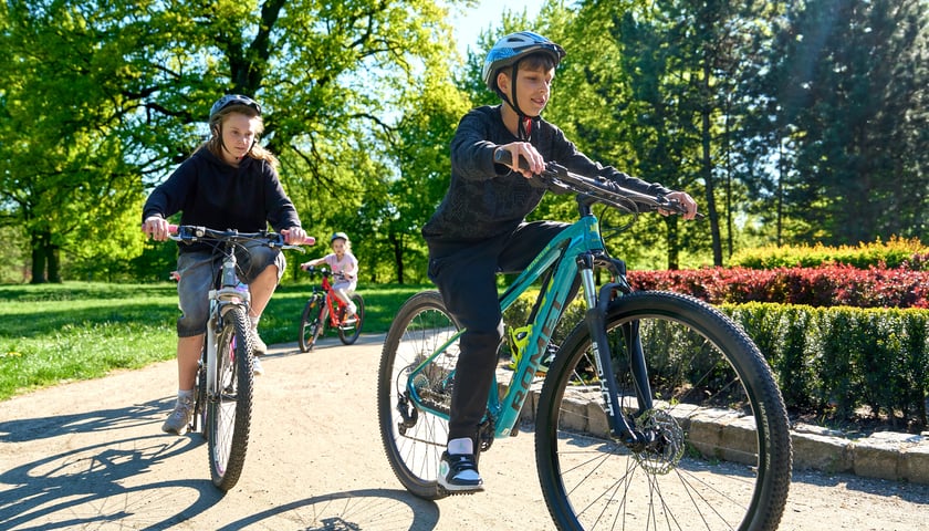 Rowerowy Maj: dzieci jadące przez park Kleciński