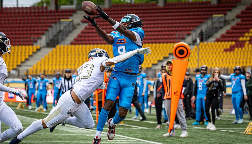 Zawodnik Panthers Wrocław łapie piłkę, atakowany przez gracza węgierskiego Fehervar Enthroners, podczas rozegranego na Stadionie Olimpijskim meczu ELF