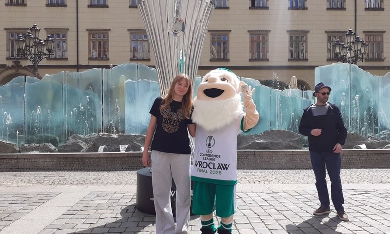 Kasia, maskotka i puchar na tle fontanny i ratusza, 23 maja 2025