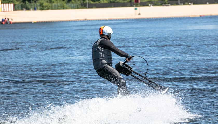 Mężczyzna pływa po wodzie jedną z desek flyboard