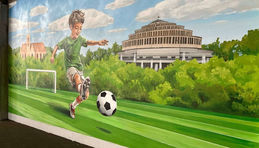 Na zdjęciu fragment nowego muralu na Tarczyński Arena Wrocław – chłopiec kopiący piłkę