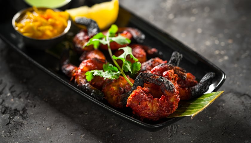 Na zdjęciu miseczka z krewetkami w indyjskich przyprawach z pieca tandoori.