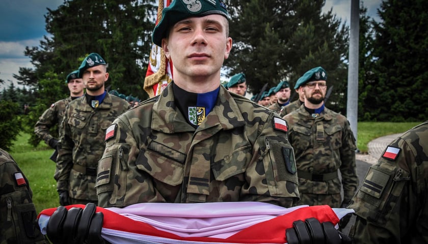 Na zdjęciu żołnierz z polską flagą