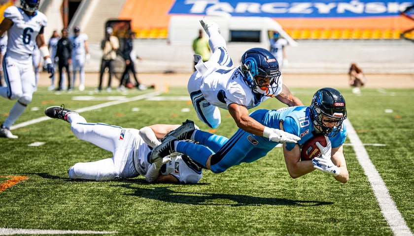Zawodnik Panthers Wrocław z piłką atakowany przez dwóch graczy drużyny Nordic Storm w czasie meczu na Stadionie Olimpijskim.