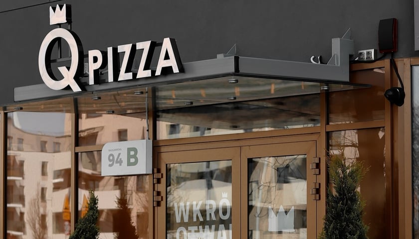 Budynek z szyldem nowej pizzerii Q Pizza we Wrocławiu.