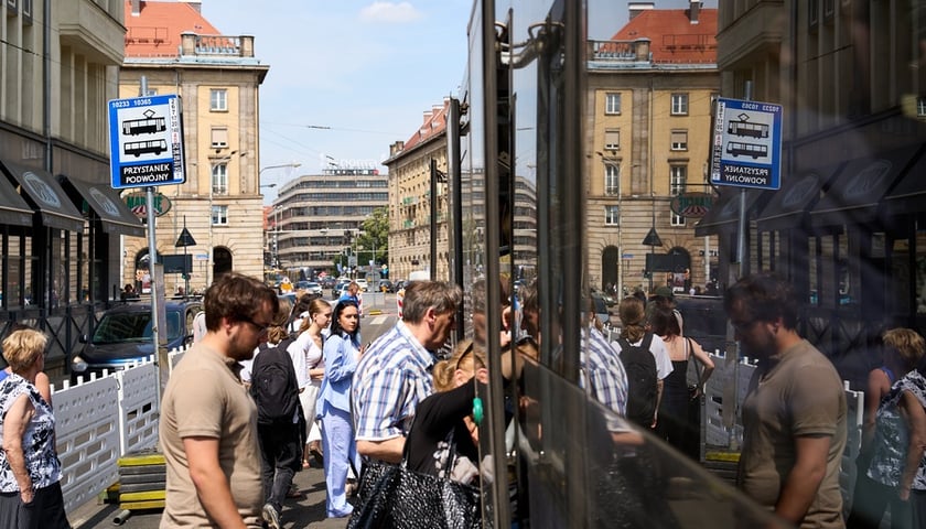 Pasażerowie przy autobusie stojącym na przystanku tymczasowym na Świdnickiej w kierunku południowym (czerwiec 2025)