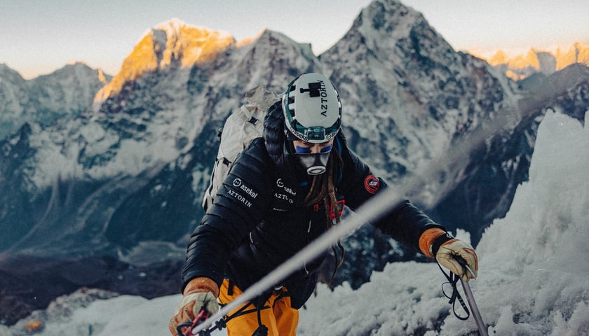 Mateusz Waligóra w czasie wejścia na Mount Everest. W tle wielkie, skaliste i ośnieżone szczyty Himalajów