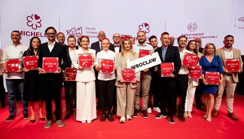Na zdjęciu wrocławscy restauratorzy z plakietkami przewodnika Michelin pozują do wspólnego zdjęcia podczas ceremonii w Hali Stulecia