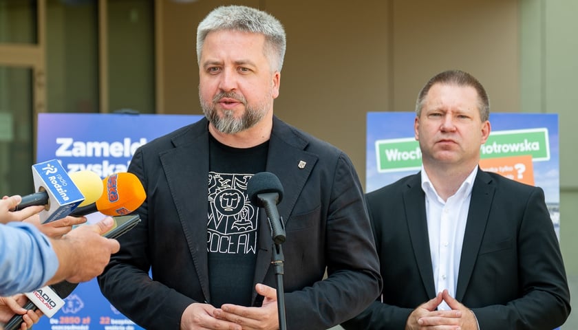 Radosław Michalski, dyrektor Departamentu Marki Miasta, Marcin Urban, skarbnik Wrocławia. Na zdjęciu dwóch mężczyzn, w tle tablice informacyjne