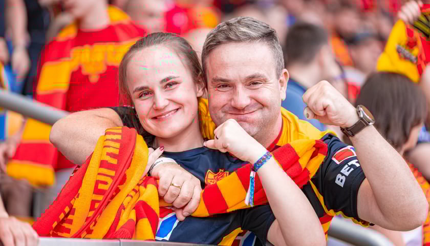 Uśmiechnięci kibice Sparty - kobieta i mężczyzna z szalikami na Olimpijskim