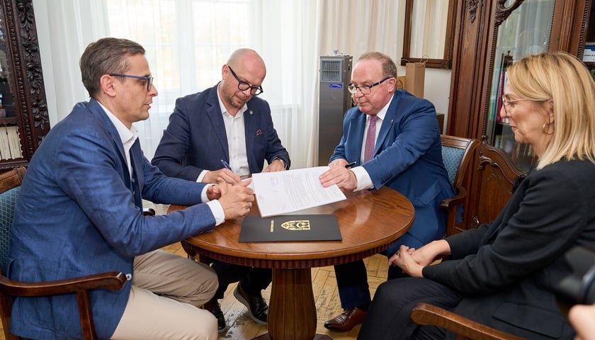 Trzech mężczyzn i kobieta, wiceprezydent Wrocławia Jakub Mazur, starosta powiatu wrocławskiego Włodzimierz Chlebosz oraz wicestarosta Marcin Korytko podpisali umowę
