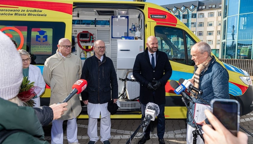 Prezydent Jacek Sutryk i przedstawiciele USK podczas uroczystości przekazania karetki.