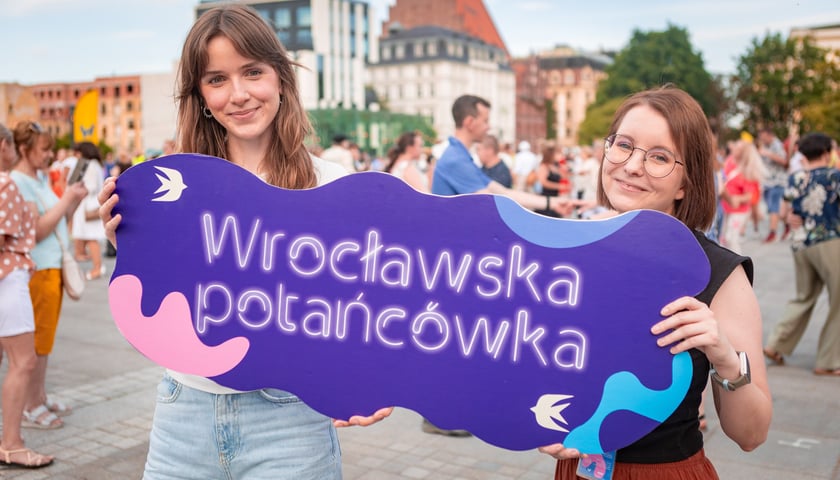 Dwoje instruktorów tańczy przed tłumem ludzi na placu Wolności we Wrocławiu