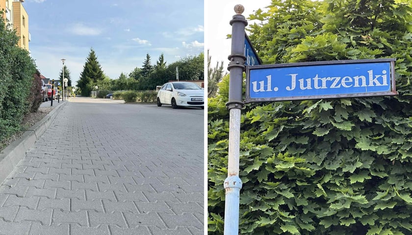 Ulica, blok mieszkalny, w tle samochód. Obok niebieska tablica z białą nazwą ul. Jutrzenki, na tle roślin