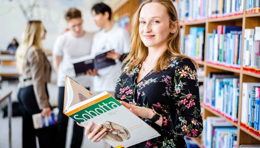 Studenci Uniwersytetu Medycznego we Wrocławiu. Na zdjęciu młoda kobieta z książką