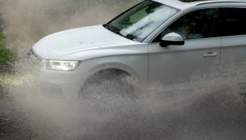 Samochód rozbryzgujący głębokie kałuże, zdjęcie archiwalne, ilustracyjne