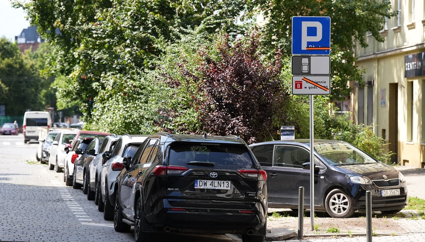 Samochody zaparkowane na ulicy księcia Witolda. Informacja o konieczności wniesienia opłaty czeka na odsłonięcie 