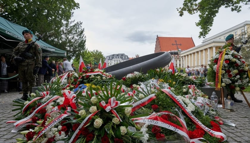 Uroczystość w rocznicę wybuchu Powstania Warszawskiego przy pomniku rotmistrza Witolda Pileckiego. Na zdjęciu wiązanki kwiatów złożone pod pomnikiem Witolda Pileckiego oraz dwóch żołnierzy pełniących wartę (zdjęcie archiwalne)