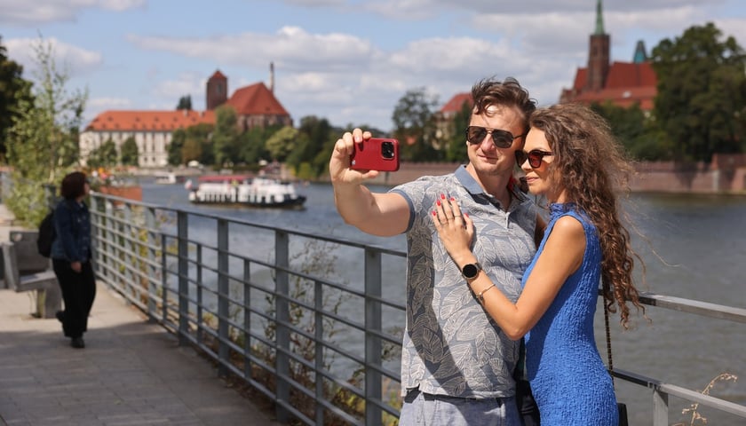 Lato w mieście. Spacerowicze robią sobie zdjęcia na tle panoramy Ostrowa Tumskiego