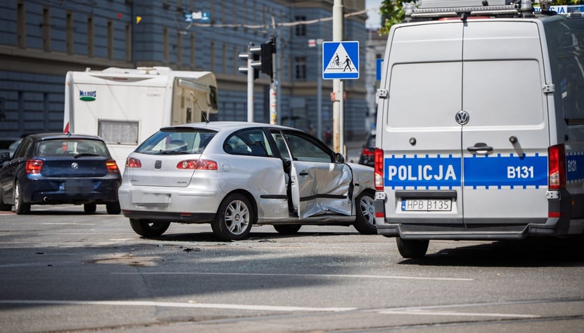 Na zdjęciu uszkodzony samochód i radiowóz policji