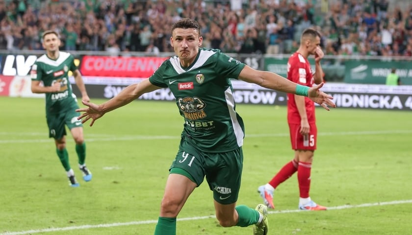 Przemysław Banaszak (zielony strój WKS-u) rozkłada ręce po golu w meczu z Miedzią Legnica we Wrocławiu (zdjęcie ilustracyjne)