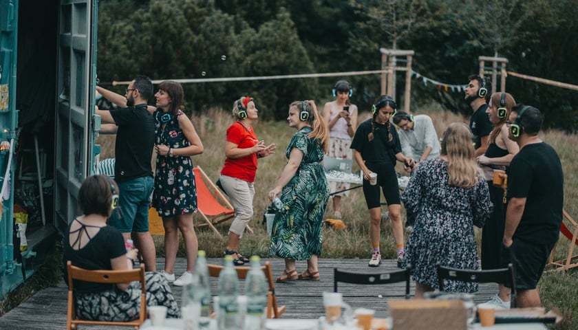 Ludzie ze słuchawkami na uszach na drewnianym podeście podczas dyskoteki silent disco - finał jednego mikrograntowego Kamienice z Ołbina