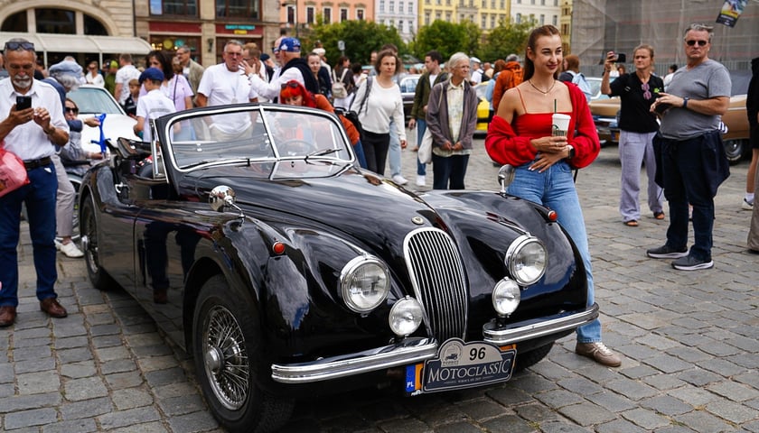 Motoclassic Wrocław w Rynku - 22 sierpnia 2025 r. Kobieta pozuje przy zabytkowym pojeździe