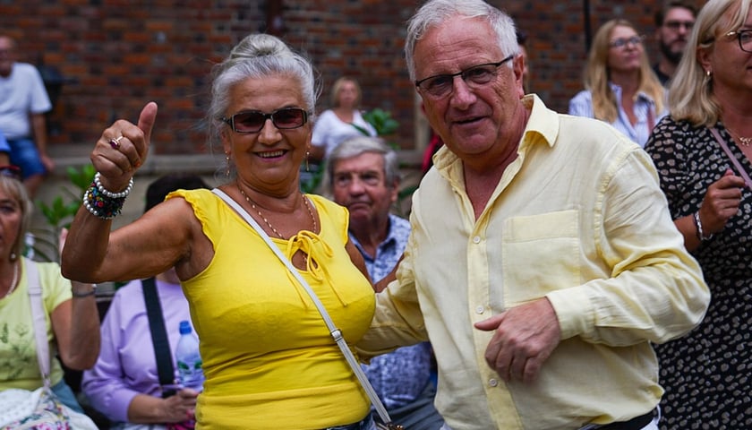 Kobieta i mężczyzna, w tle tańczący ludzie. Potańcówka na Rynku we Wrocławiu, 30.08.2025 r.  