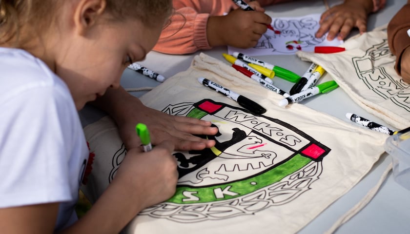 Dziewczynka kolorująca herb WKS Śląsk Wrocław