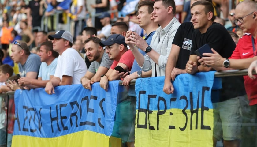 Kibice reprezentacji Ukrainy podczas meczu Ukraina - Anglia na stadionie Tarczyński Arena z żółto-niebieskimi flagami